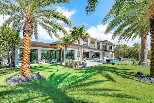 4460 NE 31st Ave, Lighthouse Point, FL 33064 - rear view of house featuring a putting green, a balcony, a lawn, a patio area, and an outdoor hangout area