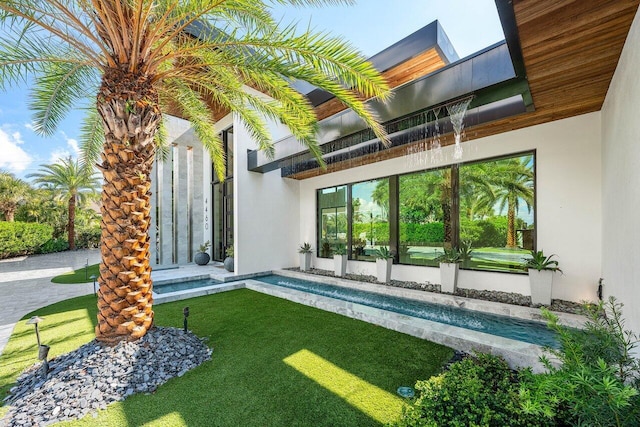 4460 NE 31st Ave, Lighthouse Point, FL 33064 - rear view of property featuring stucco siding, a lawn, and a pool with connected hot tub
