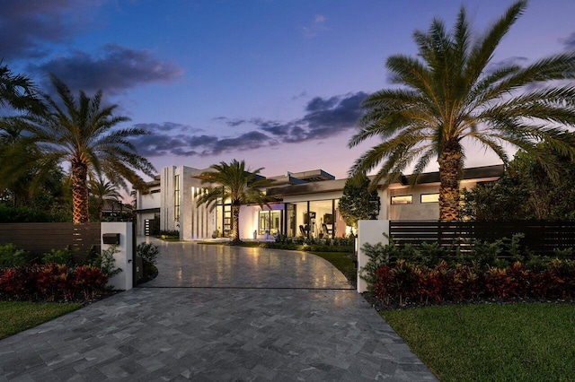 4460 NE 31st Ave, Lighthouse Point, FL 33064 - contemporary home with stucco siding, a gate, curved driveway, and a fenced front yard