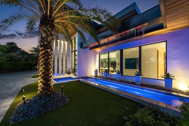 4460 NE 31st Ave, Lighthouse Point, FL 33064 - back of house featuring an outdoor pool, a jacuzzi, a lawn, and stucco siding