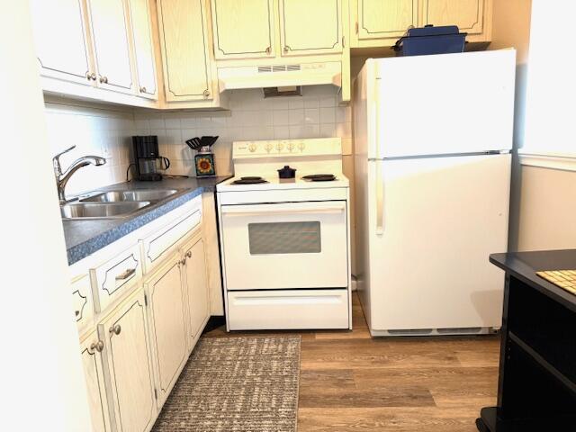 3362 Cynthia Ln Unit 211, Lake Worth Beach, FL 33461 - kitchen with white appliances, under cabinet range hood, a sink, dark countertops, and tasteful backsplash