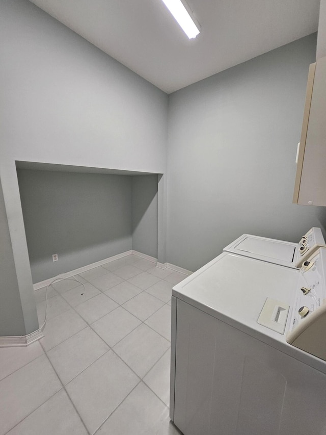 1639 SW Harbour Isles Cir Unit 29, Port Saint Lucie, FL 34986 - laundry room featuring washing machine and clothes dryer, light tile patterned floors, and baseboards
