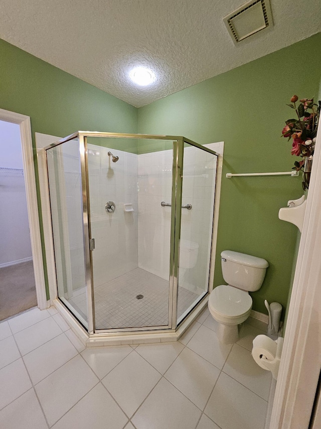 1639 SW Harbour Isles Cir Unit 29, Port Saint Lucie, FL 34986 - bathroom with toilet, a stall shower, tile patterned flooring, a textured ceiling, and a spacious closet