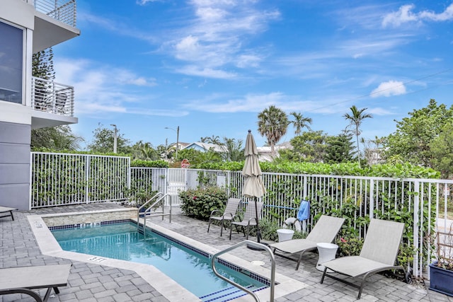 community pool with a patio and a fenced backyard