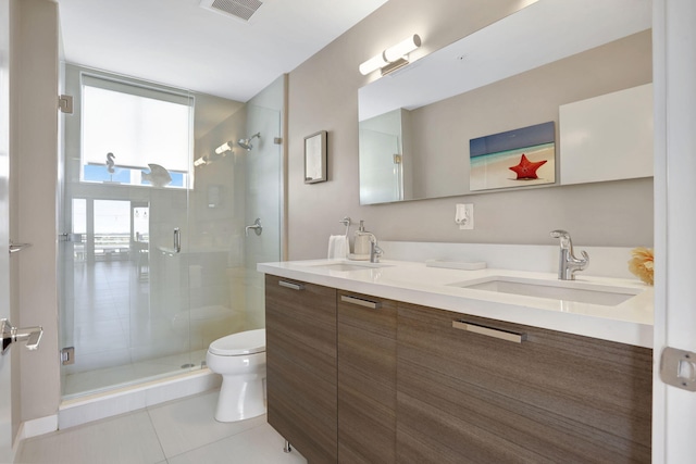 bathroom featuring a shower stall, tile patterned floors, toilet, and double vanity