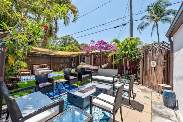 view of patio with an outdoor living space with a fire pit and a fenced backyard