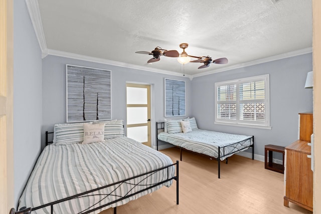 bedroom featuring ornamental molding, light wood-style floors, baseboards, a textured ceiling, and a ceiling fan