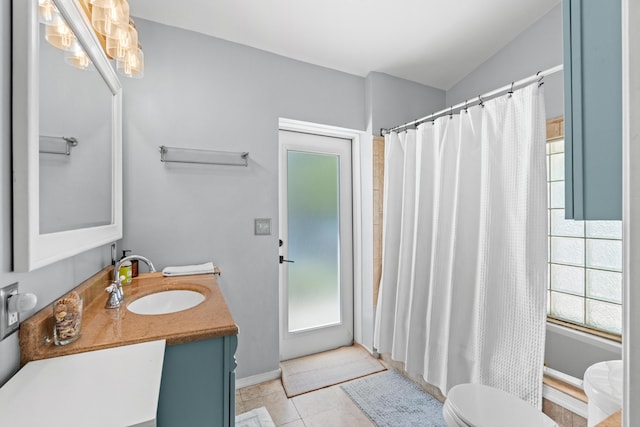 bathroom featuring toilet, healthy amount of natural light, vanity, a shower with curtain, and vaulted ceiling