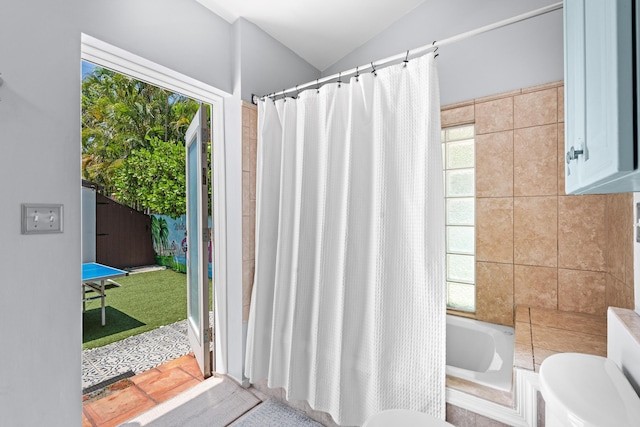 full bathroom with plenty of natural light, toilet, lofted ceiling, and a bathtub