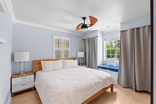 bedroom featuring crown molding, light wood-type flooring, a textured ceiling, and ceiling fan