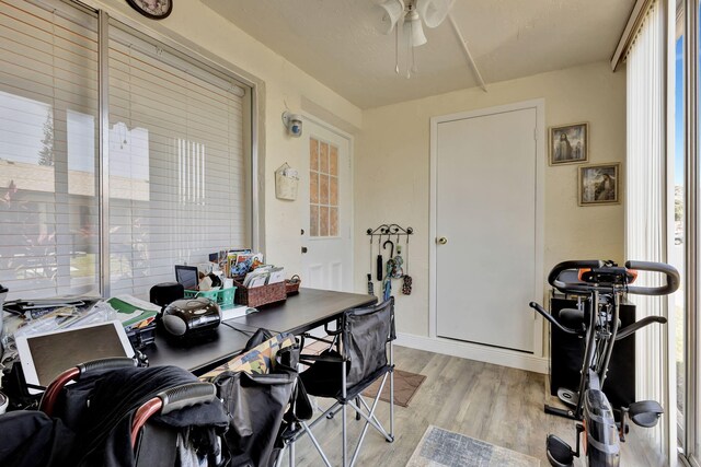 office area featuring light wood-type flooring, ceiling fan, and baseboards