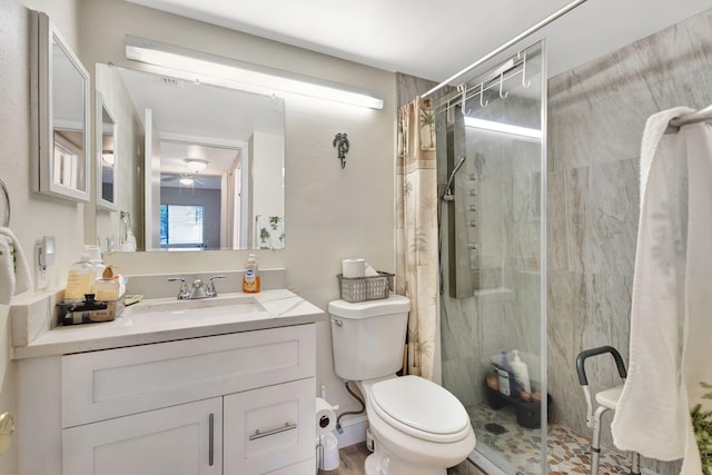full bath with a shower stall, toilet, vanity, and a ceiling fan