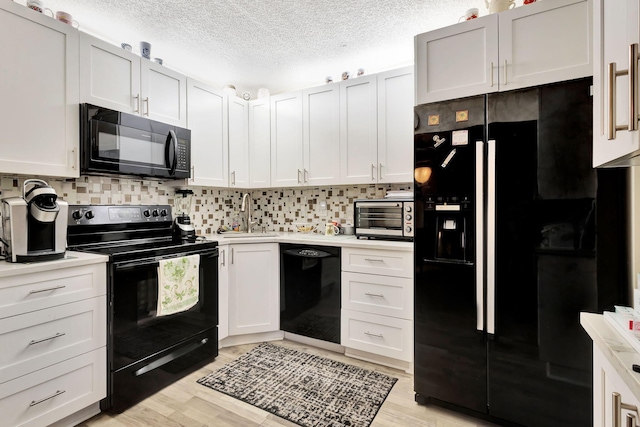 kitchen featuring black appliances, a sink, light countertops, and a textured ceiling