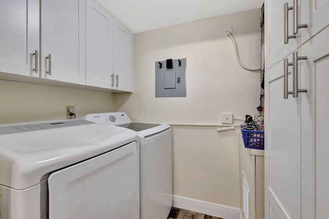 laundry room featuring cabinet space, independent washer and dryer, electric panel, baseboards, and wood finished floors