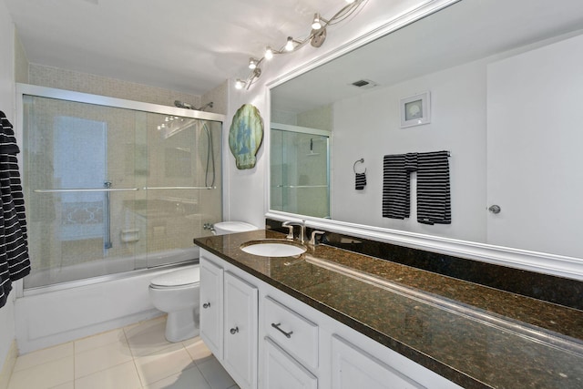 full bath with toilet, vanity, bath / shower combo with glass door, and tile patterned floors