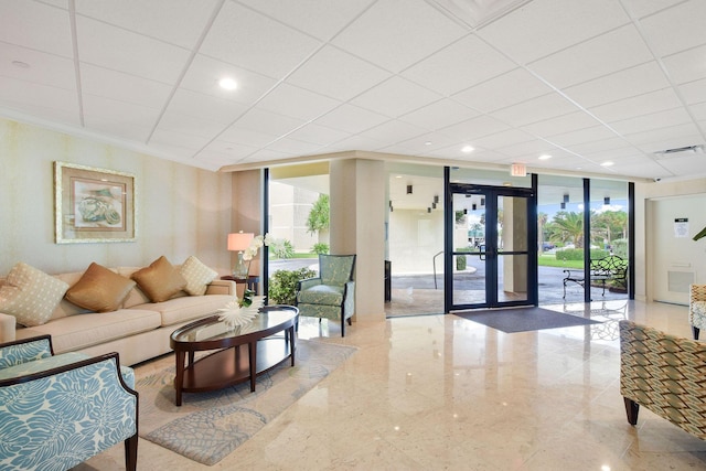 community lobby featuring a drop ceiling, expansive windows, and recessed lighting