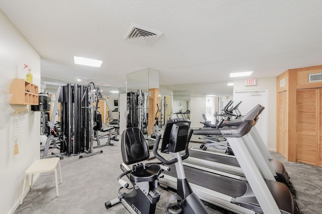 gym featuring carpet and a textured ceiling