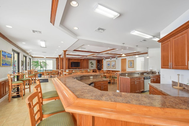 kitchen with dishwasher, recessed lighting, brown cabinetry, coffered ceiling, and light tile patterned flooring