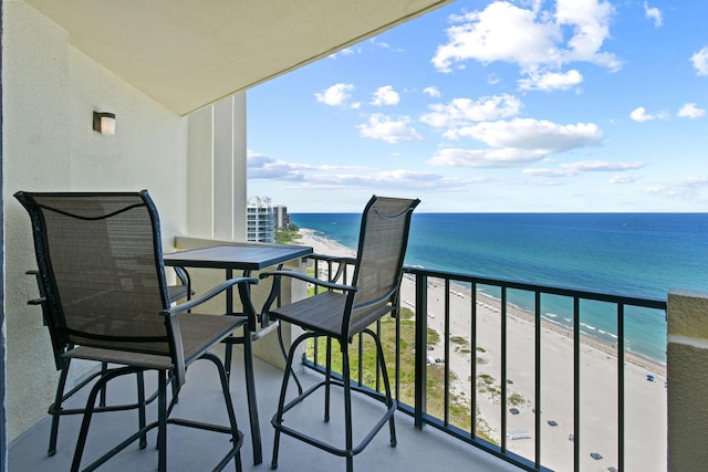 balcony with view of water and beach