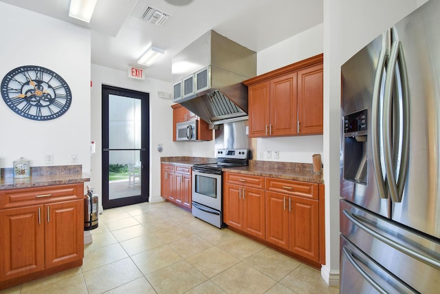 kitchen featuring appliances with stainless steel finishes, light tile patterned floors, and brown cabinets