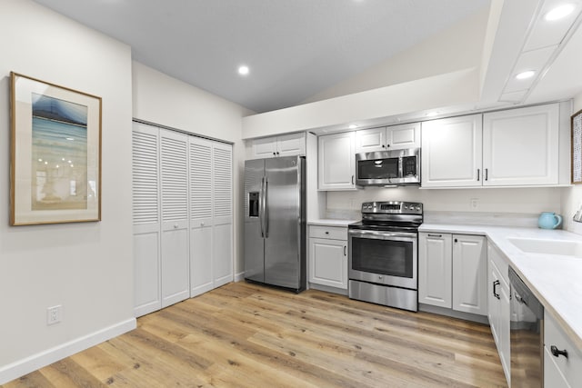 701 Sea Oats Dr Unit A-4, Juno Beach, FL 33408 - kitchen featuring appliances with stainless steel finishes, light countertops, light wood finished floors, vaulted ceiling, and recessed lighting