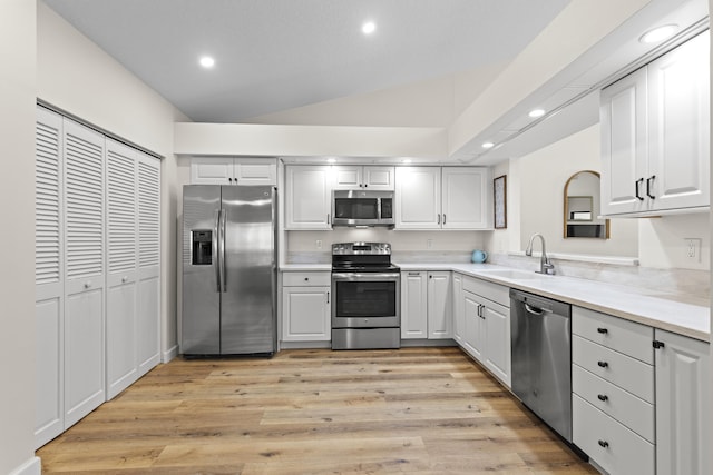 701 Sea Oats Dr Unit A-4, Juno Beach, FL 33408 - kitchen featuring stainless steel appliances, recessed lighting, lofted ceiling, light wood-style floors, and light countertops