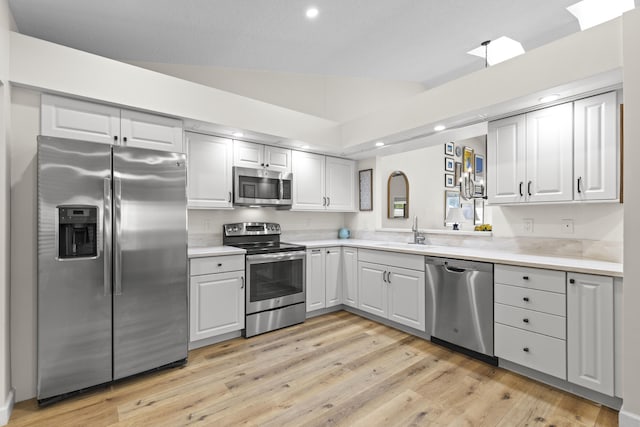 701 Sea Oats Dr Unit A-4, Juno Beach, FL 33408 - kitchen with stainless steel appliances, recessed lighting, light countertops, light wood-style floors, and lofted ceiling