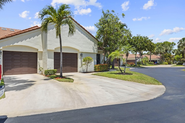 701 Sea Oats Dr Unit A-4, Juno Beach, FL 33408 - view of front of home featuring concrete driveway, stucco siding, an attached garage, and a tile roof