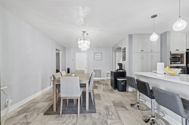 8611 NW 47th Ct, Lauderhill, FL 33319 - dining area featuring arched walkways, a chandelier, and baseboards