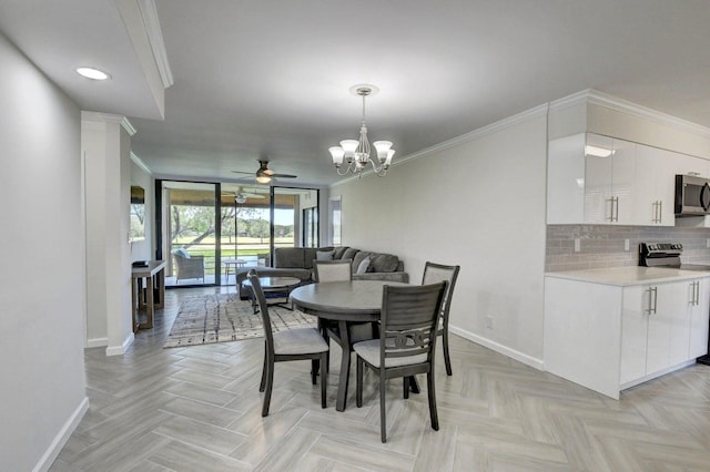 dining area featuring baseboards, crown molding, a chandelier, and a ceiling fan