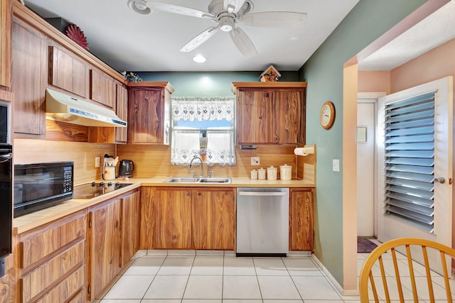 kitchen with a sink, black appliances, under cabinet range hood, light countertops, and ceiling fan