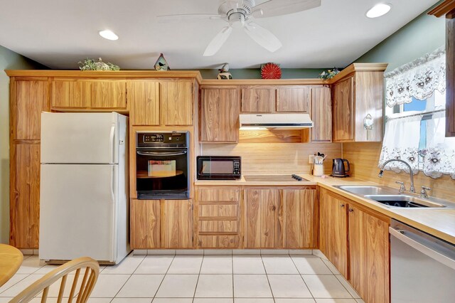 kitchen featuring black appliances, a sink, under cabinet range hood, light countertops, and decorative backsplash