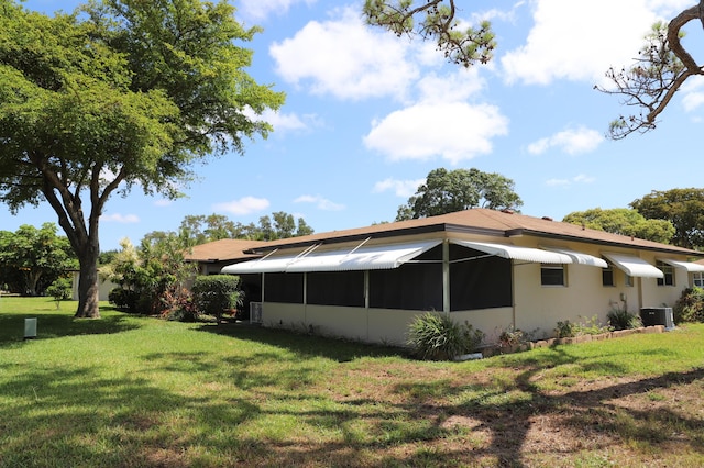 521 Sandpiper Cir, Delray Beach, FL 33445 - rear view of house with central AC unit and a lawn