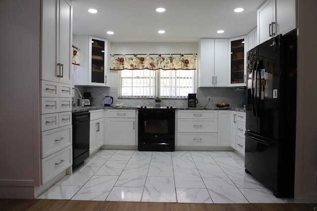 521 Sandpiper Cir, Delray Beach, FL 33445 - kitchen featuring black appliances, light marble finish floors, light stone countertops, white cabinets, and glass insert cabinets