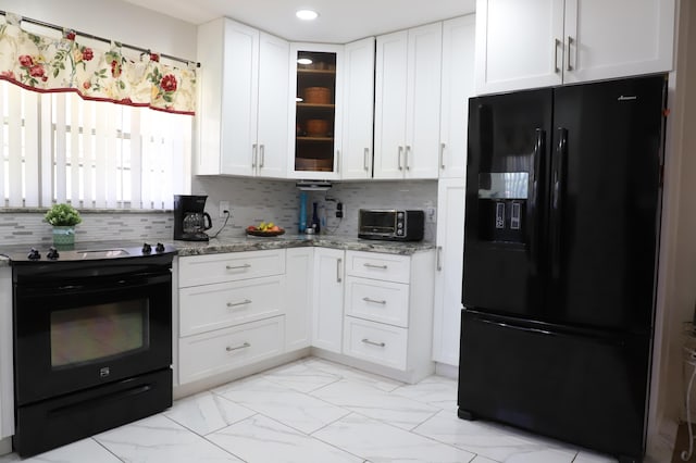 521 Sandpiper Cir, Delray Beach, FL 33445 - kitchen featuring black appliances, light marble finish flooring, glass insert cabinets, light stone counters, and white cabinets