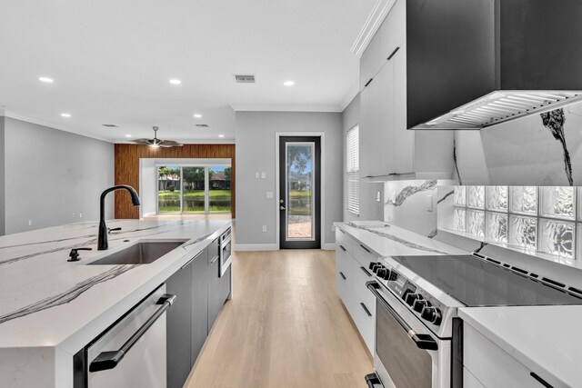 14838 Strand Ln, Delray Beach, FL 33446 - kitchen with appliances with stainless steel finishes, a sink, modern cabinets, recessed lighting, and light wood-style flooring