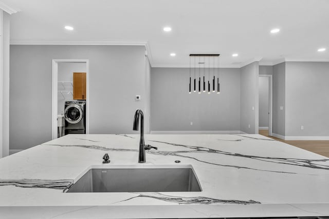 14838 Strand Ln, Delray Beach, FL 33446 - kitchen featuring washer / dryer, light stone counters, recessed lighting, ornamental molding, and a sink