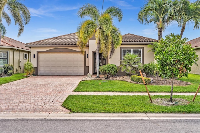 14838 Strand Ln, Delray Beach, FL 33446 - mediterranean / spanish-style home with a garage, decorative driveway, stucco siding, and a tile roof