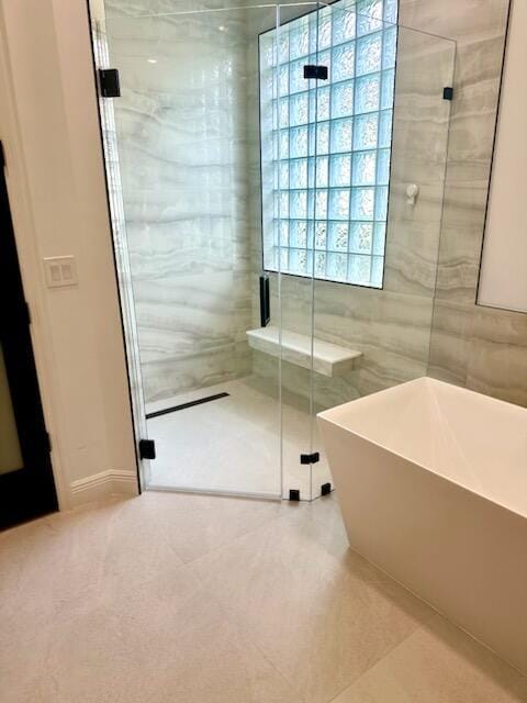 14838 Strand Ln, Delray Beach, FL 33446 - bathroom featuring a soaking tub, a stall shower, tile walls, and tile patterned floors
