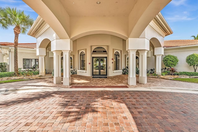 14838 Strand Ln, Delray Beach, FL 33446 - view of exterior entry featuring french doors, stucco siding, and a tiled roof