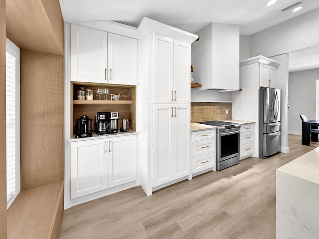 1726 SW Erie St, Port Saint Lucie, FL 34953 - kitchen with appliances with stainless steel finishes, open shelves, white cabinetry, backsplash, and light wood-style floors