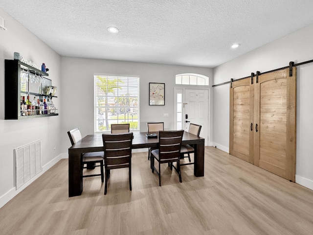 1726 SW Erie St, Port Saint Lucie, FL 34953 - dining room with a barn door, light wood-style floors, a textured ceiling, baseboards, and recessed lighting