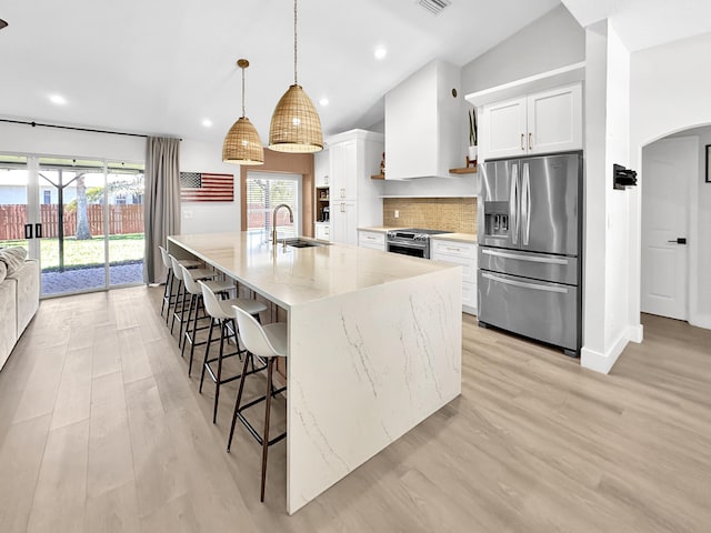 1726 SW Erie St, Port Saint Lucie, FL 34953 - kitchen with appliances with stainless steel finishes, a sink, vaulted ceiling, arched walkways, and a kitchen bar