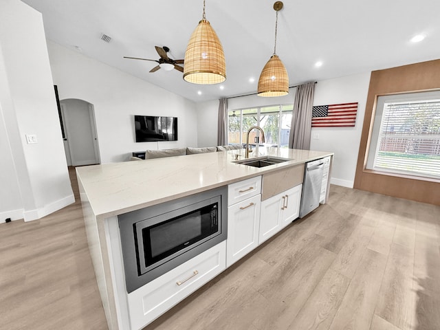 1726 SW Erie St, Port Saint Lucie, FL 34953 - kitchen with a sink, appliances with stainless steel finishes, light wood-style floors, white cabinetry, and an island with sink