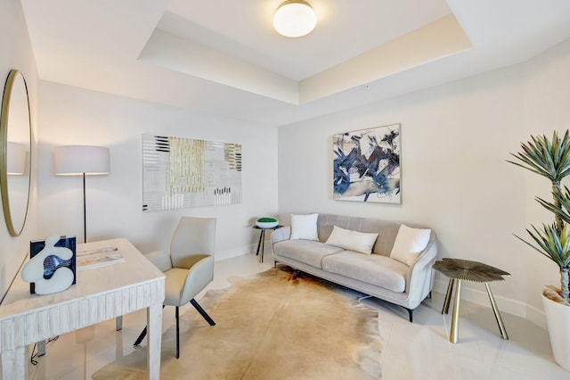 office area featuring baseboards, a raised ceiling, and tile patterned flooring