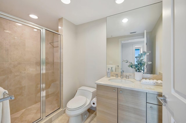 bathroom with a stall shower, toilet, vanity, and recessed lighting
