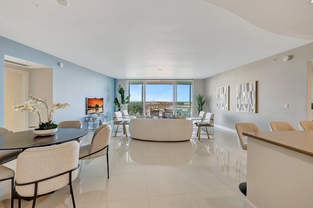 living room featuring expansive windows, light tile patterned flooring, and baseboards