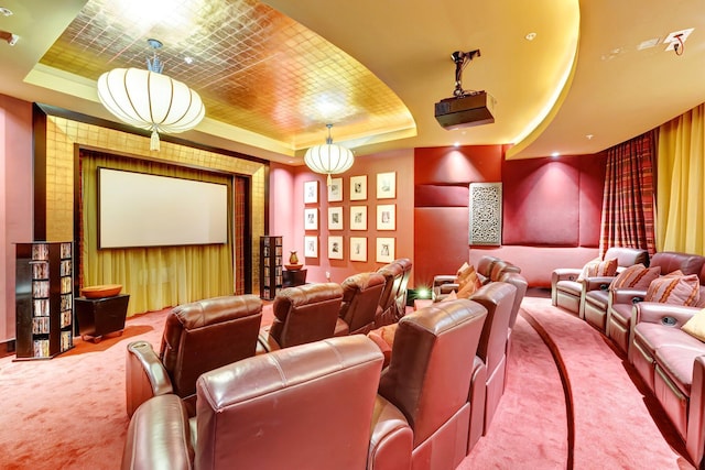 carpeted home theater with a tray ceiling