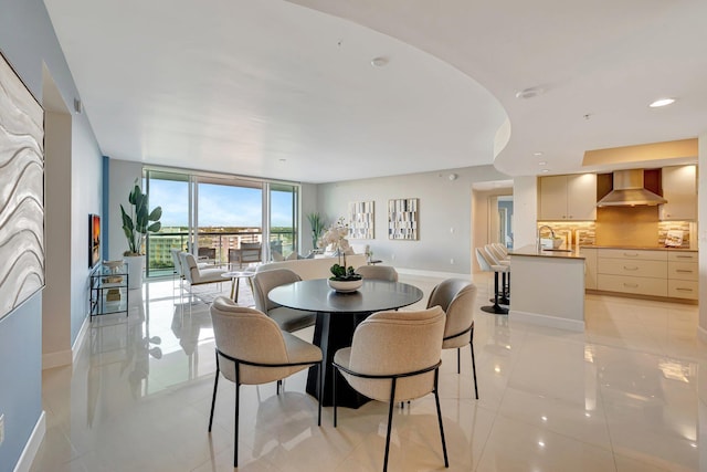 dining room with light tile patterned floors, floor to ceiling windows, baseboards, and recessed lighting