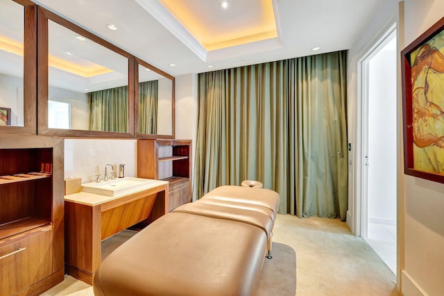 bathroom with a raised ceiling, vanity, and recessed lighting